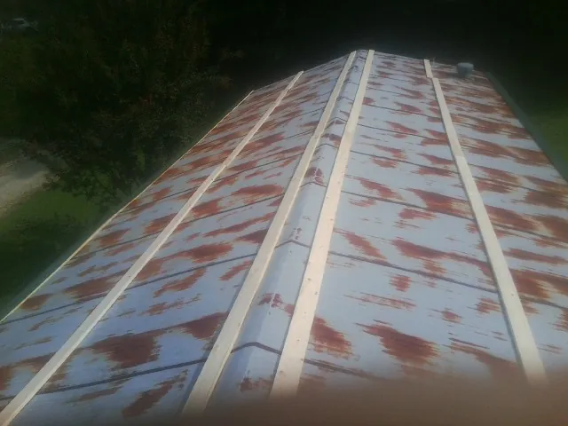 Rusted metal roof panels with new wood purlins before replacement — Storm Damage Roof Repair in Benton City by Roofing Brothers