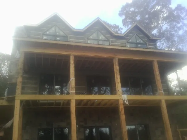 Dormers and porch framing on a large log home under construction — Roof Coating work by our crew in Benton City